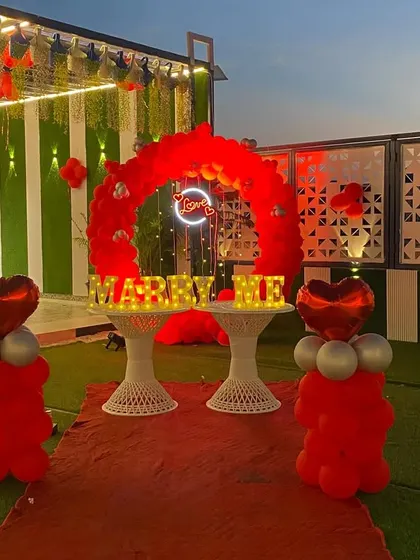 The proposal decoration looks just as stunning as the sun sets. The glowing "MARRY ME" letters and the neon "Love" sign create a magical ambiance for an evening proposal.