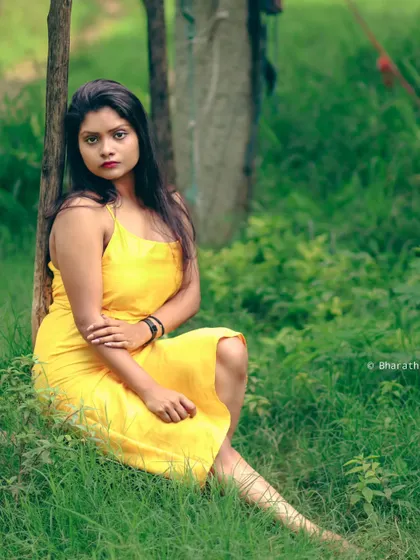 A classic seated portrait in a park. The composition is simple and timeless, focusing on the subject's relaxed pose.
