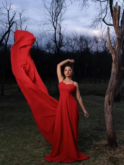 A moment of pure artistry. The bride's pose and the dramatic sweep of the red trail gown create a powerful and captivating image, perfect for a fine art pre-wedding album.