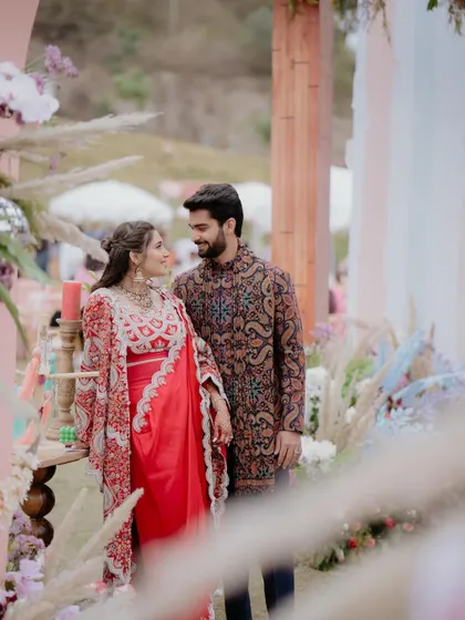 The couple framed by our custom-designed decor. The soft textures and pastel colors of the backdrop made their vibrant outfits pop beautifully.