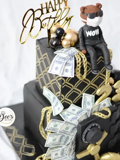 Show me the money. This cake is all about the high life, featuring a sculpted money vault, edible dollar bills, and a cool teddy bear topper.