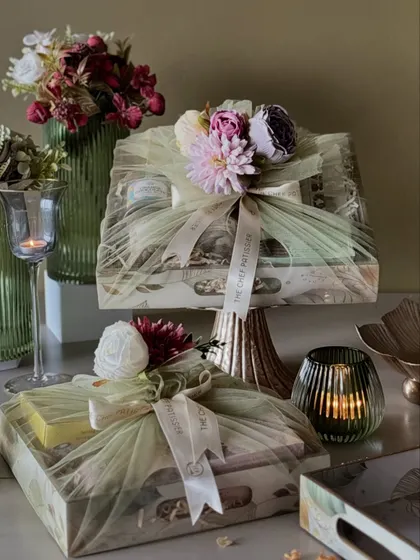We offer hampers in all shapes and sizes, like these beautifully wrapped trays. The one on the stand adds a touch of height and drama, making it a stunning centerpiece for a Diwali party.