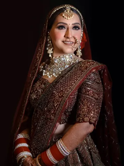 The party doesn't start until the bride walks in. A classic, smiling portrait of the bride in her rich, dark red lehenga.
