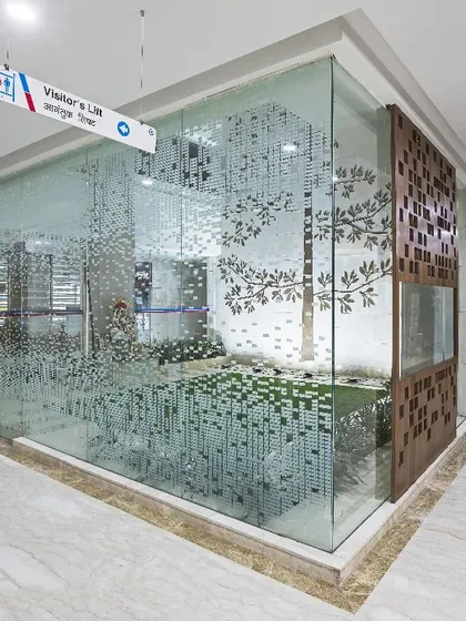 The central courtyard at Aakash Super-Specialty Hospital is inspired by Japanese Zen Gardens. This space, complete with a water body and artistic glass partitions, is the heart of the building, breaking away from the stereotypical clinical environment.