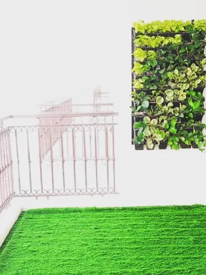 A simple, minimalist approach can be very effective. A small patch of green turf and a single vertical garden module are enough to bring life and style to this clean, modern balcony.