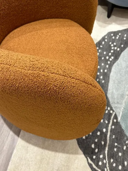 An overhead detail of the 'Otto' chair, showing the texture of the boucle fabric and the deep, comfortable seat.
