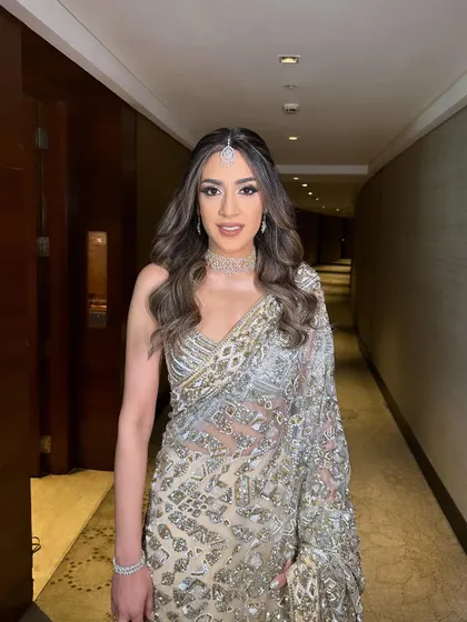 A three-quarter view that captures the shimmer of the saree and the soft, glamorous makeup.