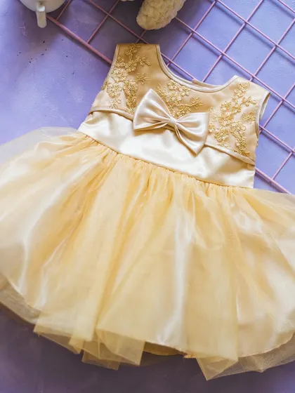A beautiful golden-yellow party frock. This dress features delicate floral embroidery on the bodice and a full tulle skirt, making it a wonderful choice for a festive occasion.