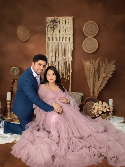 A regal and loving portrait of the expecting couple. The mom-to-be looks radiant in a ruffled pink gown, perfectly complemented by the earthy tones of our boho set.
