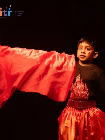 A boy waves a red cloth, dramatically representing the power and movement of fire in our "Pancha Tattva" performance.