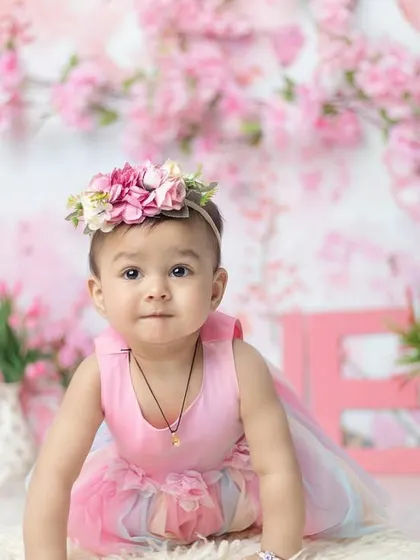 A crawling pose amidst the flowers. This shows a different angle of the beautiful, immersive pink floral setup.