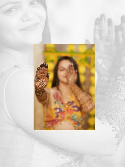 An artistic shot of the bride peeking through her henna-covered hand. It's a playful and creative way to showcase the Mehandi design.