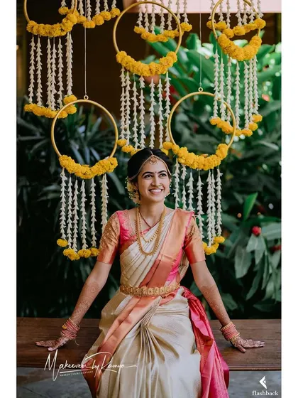 Sharvari seated on a swing adorned with marigolds, looking like a picture of bridal perfection.