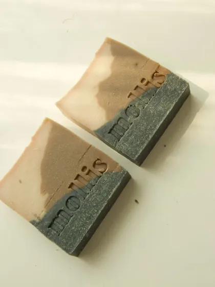 A duo of layered charcoal and clay soaps.