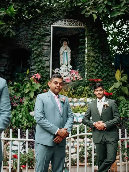 The groom and his groomsmen stand ready for the Catholic wedding ceremony. The coordinated suits and the serene church garden setting create a classic and elegant pre-ceremony portrait.