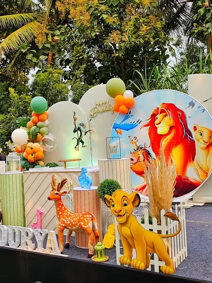 A grand Lion King first birthday party. This outdoor stage setup is filled with characters like Simba, Mufasa, Timon, and Pumbaa, set against a Pride Lands backdrop.