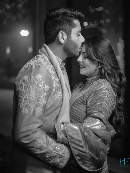 A timeless black and white portrait of the groom kissing his bride's forehead, a simple and powerful expression of love.