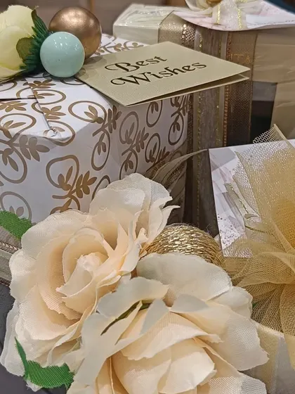 A collection of elegantly wrapped gifts with floral toppers, part of a larger engagement hamper, showing how every detail is curated.