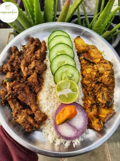 A special meal with fish curry and a unique chicken feet and liver stir fry, served with rice and fresh cucumber.