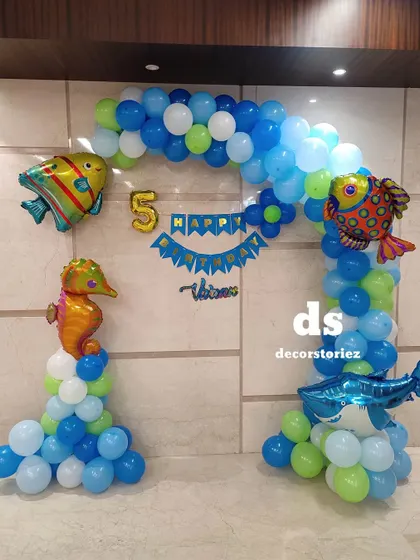 A clear, straight-on view of the ocean-themed balloon arch, showing the 'Happy Birthday' banner and the number '5' foil balloon for a fifth birthday party.