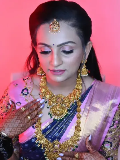 This bride is admiring her final look. The soft pink lighting highlights the glow on her skin and the intricate gold jewellery.