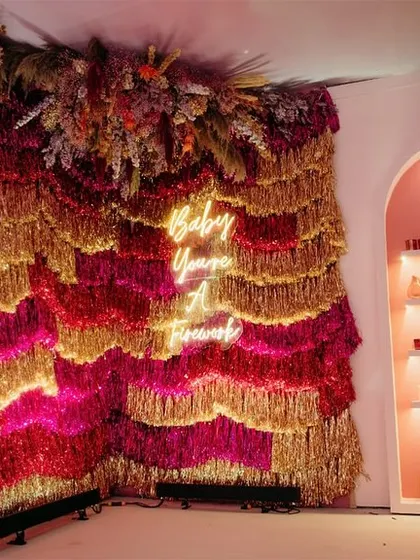 "Baby you're a firework!" This sparkling tinsel and neon sign photo booth was a huge hit, serving as a reminder for everyone to shine brightly.