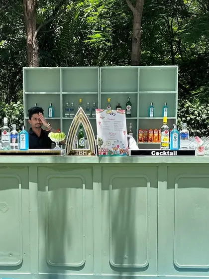 A beautiful mint-green bar setup for a daytime garden party. This vintage-style counter provides a fresh and elegant look, fully stocked and ready for service with one of our bartenders.