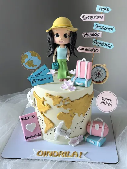 A cake for a travel lover. This design features a world map, a passport, and a handcrafted figurine of a girl with her luggage, ready for her next adventure.