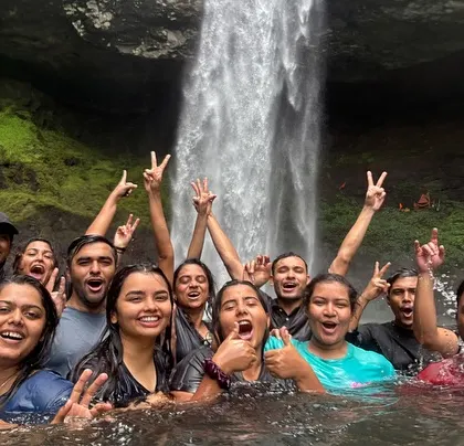 Pure joy! A group cheers for the camera while taking a dip in the Devkund waterfall pool.