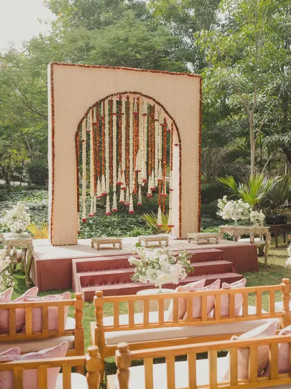 A simple yet elegant seating area on the lawn, with a beautiful backdrop of hanging flowers.