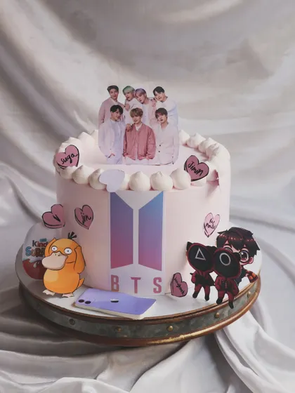 For the BTS ARMY! This cake has it all: the BTS logo, a group photo topper, and even little details from Squid Game and Pokémon. It’s a true pop culture celebration.