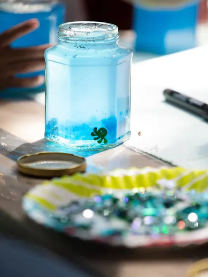 A close-up of our "ocean in a jar" craft station. Kids get to create their own mini aquarium with water beads, glitter, and tiny sea creature figures, combining sensory play with creativity.