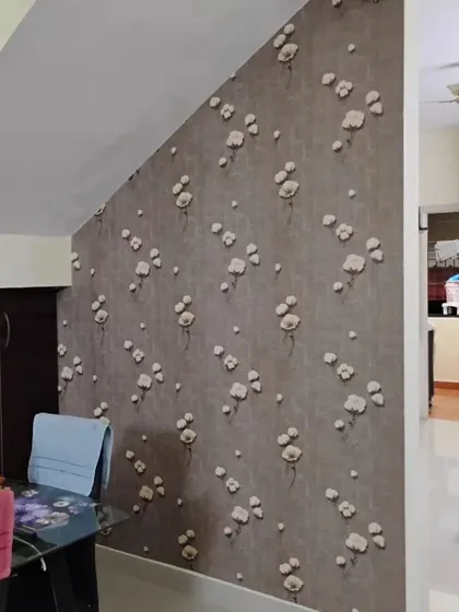 A dining area wall featuring a wallpaper with a scattered floral pattern. The design is simple and elegant, adding a touch of charm to the space.