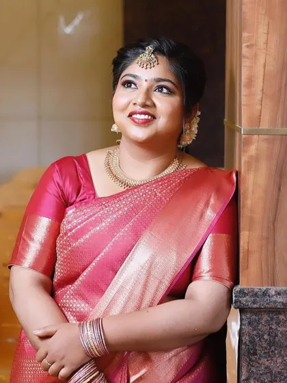 All set for her sister's baby shower. This look features a classic red lip and defined eyes, a timeless combination that looks beautiful with her pink silk saree.