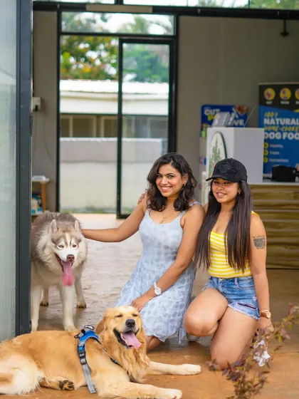 A proud pet parent with her two well-behaved dogs, a husky and a golden retriever, at our reception area.