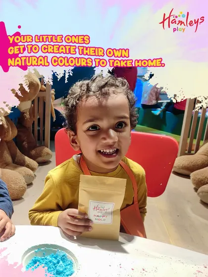 Look at that smile! A young child proudly holds up his finished packet of homemade natural Holi colors. This is what play with purpose looks like.