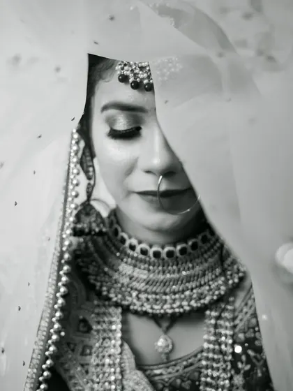 A serene black and white portrait of the bride under her veil, her eyes closed in a moment of quiet contemplation.