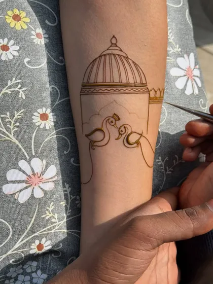 The beginning stages of an arm band design, showing the outline of two peacocks and a dome. This is the first step to creating a masterpiece.