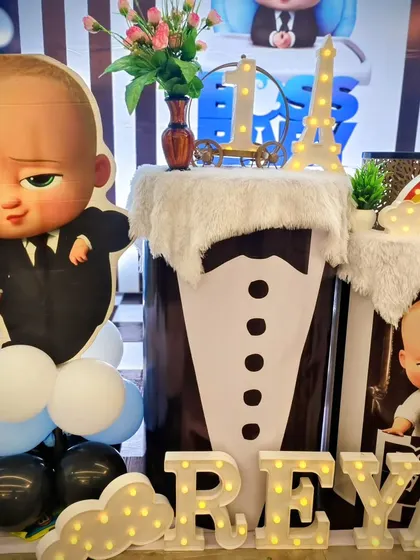 A close-up of the Boss Baby props, including a tuxedo-themed pedestal and light-up name.