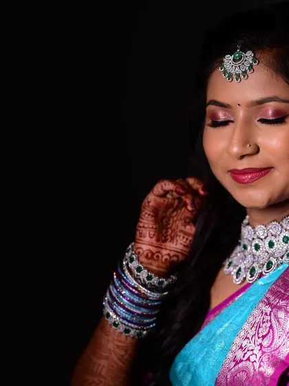 A close up of a bride's reception makeup. The focus is on the shimmery pink eyeshadow and perfectly defined eyes, paired with a matching lip colour.