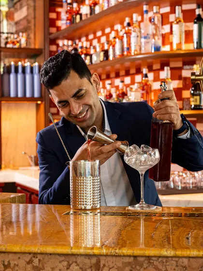 Varun carefully measures ingredients, showcasing the precision and craft that goes into every cocktail.