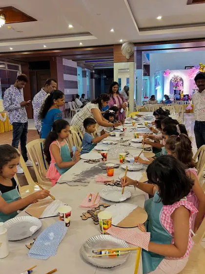 This is what a creative party setup looks like. A long table filled with kids in aprons, completely absorbed in their painting. I make sure every child has their own station with all the supplies they need to get started.