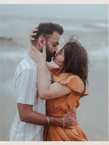 A passionate and intimate kiss, with the wind and waves adding to the drama of the moment.