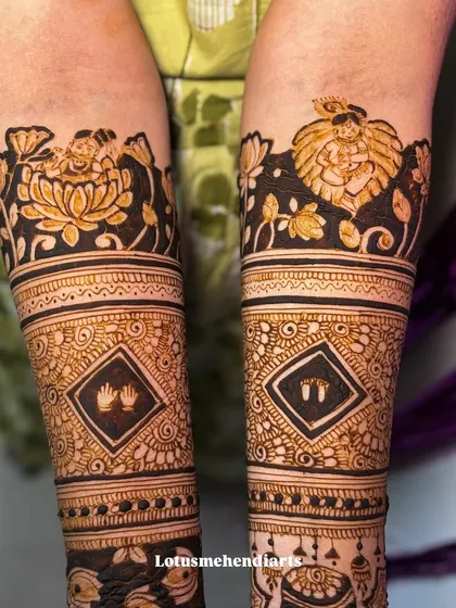 A close-up of the baby shower mehendi, showing the detailed work on the baby Krishna and lotus motifs, along with tiny baby handprints and footprints.