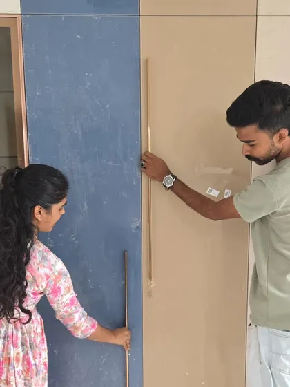 Our team is hands-on, ensuring every detail is perfect. Here, our designers are on-site, personally overseeing the installation of wardrobe handles to guarantee the final look is exactly as planned.