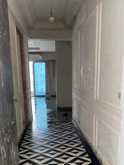 The foyer during renovation, with new geometric tiles laid and walls prepped for paneling.