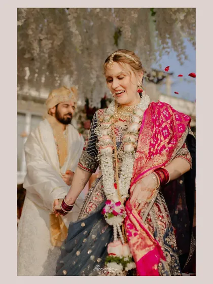 The bride's happy expression as she walks with her groom during their beachside Gujarati wedding ceremony.