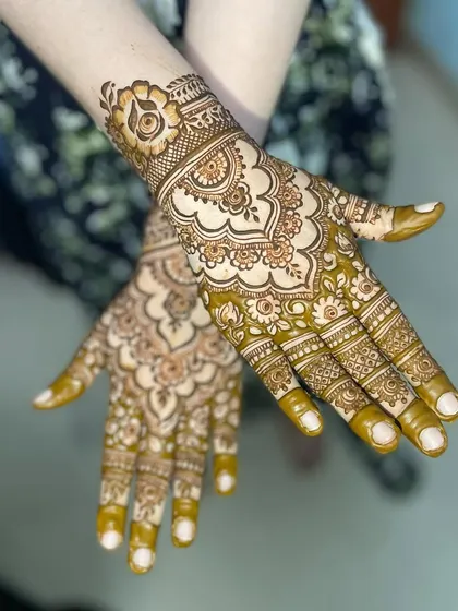 A stunning full-hand design with a large floral cuff. The use of negative space around the central mandala makes the pattern stand out beautifully.
