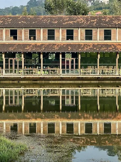 A wider view of the ODEA' restaurant, showing how it sits within the larger landscape of the Riverside Retreat. The architecture is respectful of its setting, enhancing the natural beauty rather than competing with it.