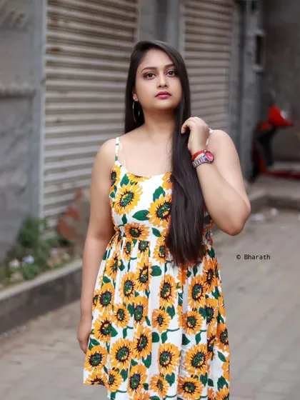 A standing portrait on a city street, capturing a moment of quiet confidence amidst the urban hustle.